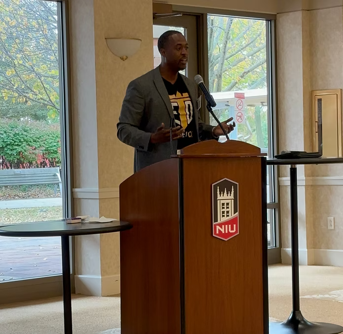 Aaron Smith speaking at podium