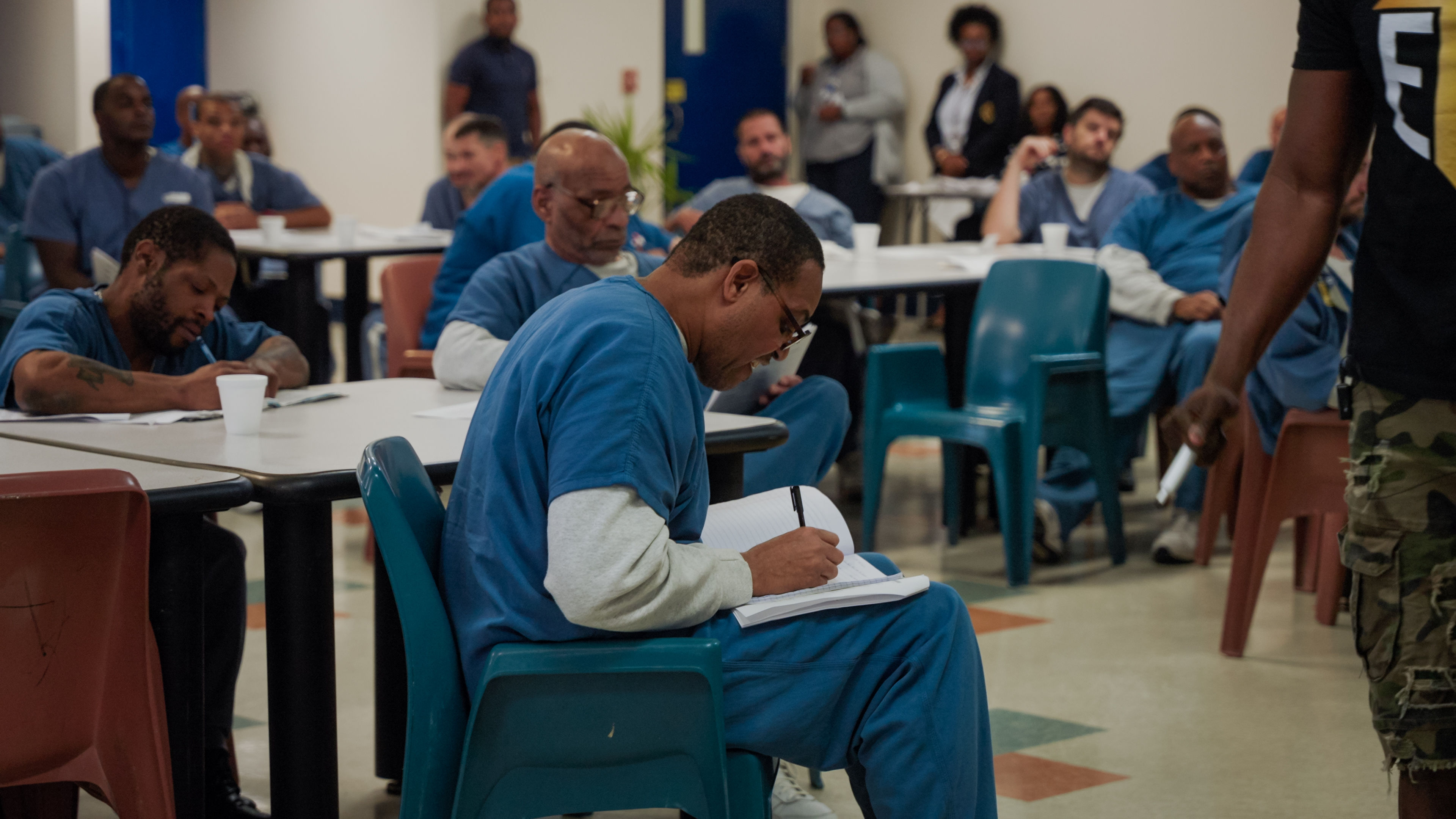 Students in blue writing during vocational program session